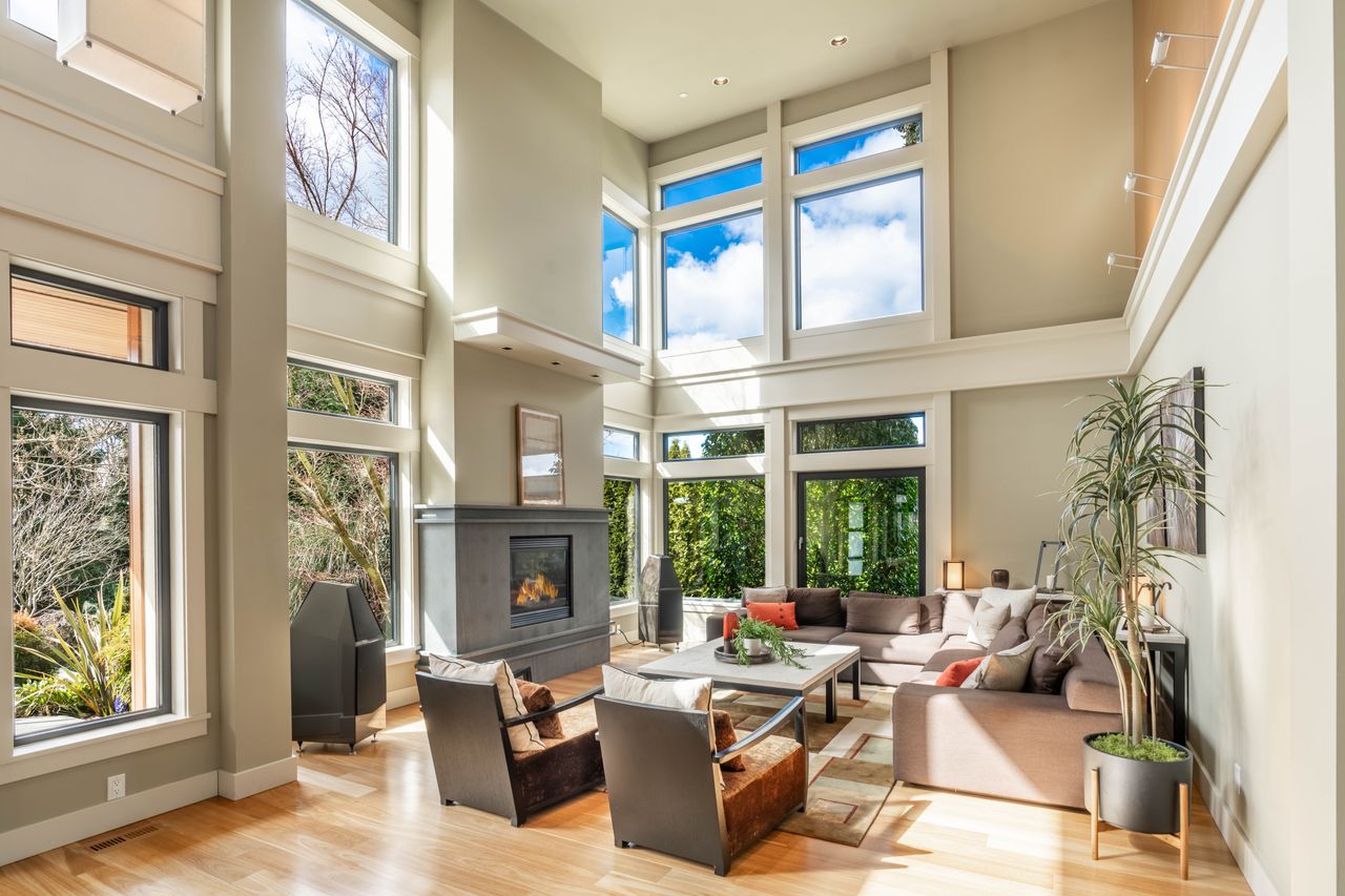 Mastering the First Impression: Your intriguing post title goes here Bright and airy living room with tall windows, elegant decor, and a cozy fireplace.