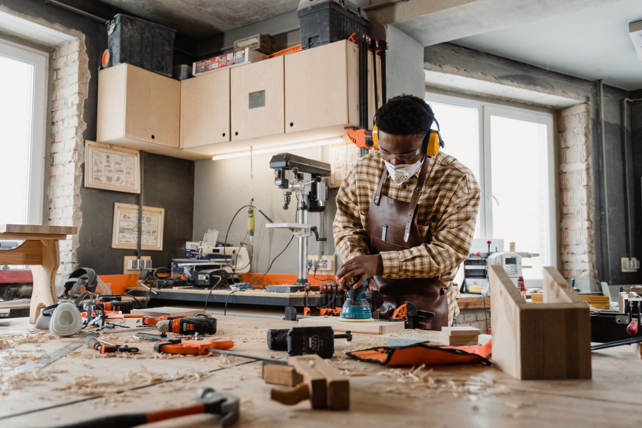 services-01 A skilled craftsman working with tools in a well-equipped woodworking workshop.