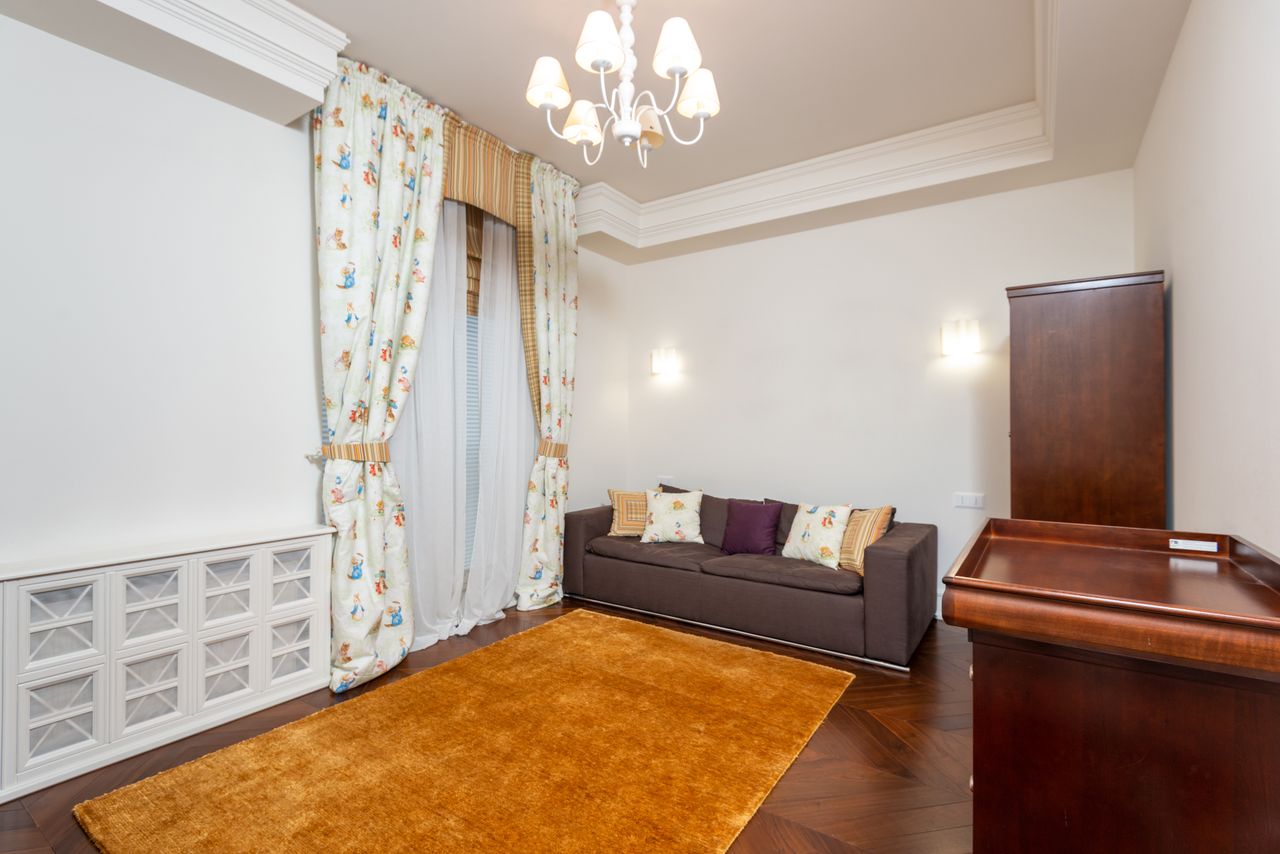 our-experience Bright and spacious living room featuring elegant chandelier, cozy sofa, and tasteful decor for a stylish ambiance.