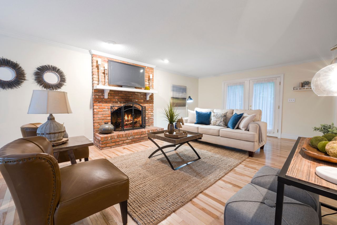 about-img Inviting living room featuring cozy seating, brick fireplace, and stylish decor.